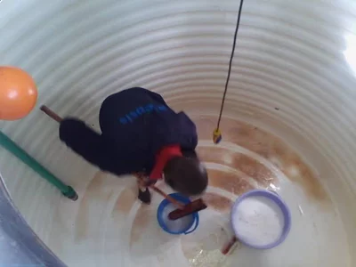  homme nettoyant un réservoir d'eau de citerne