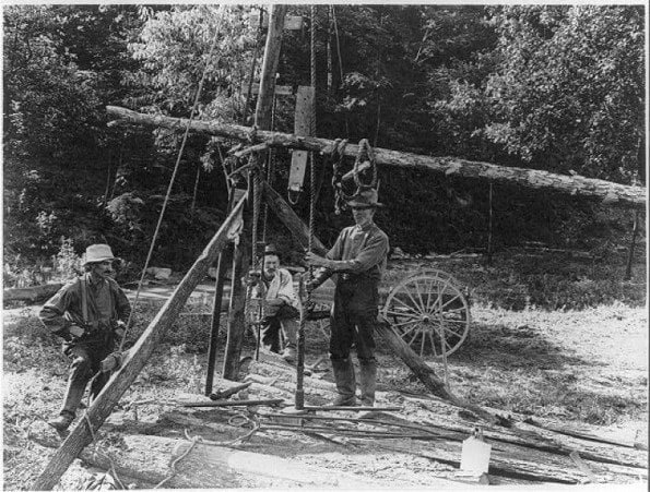 Vintage photo of men drilling a well by hand