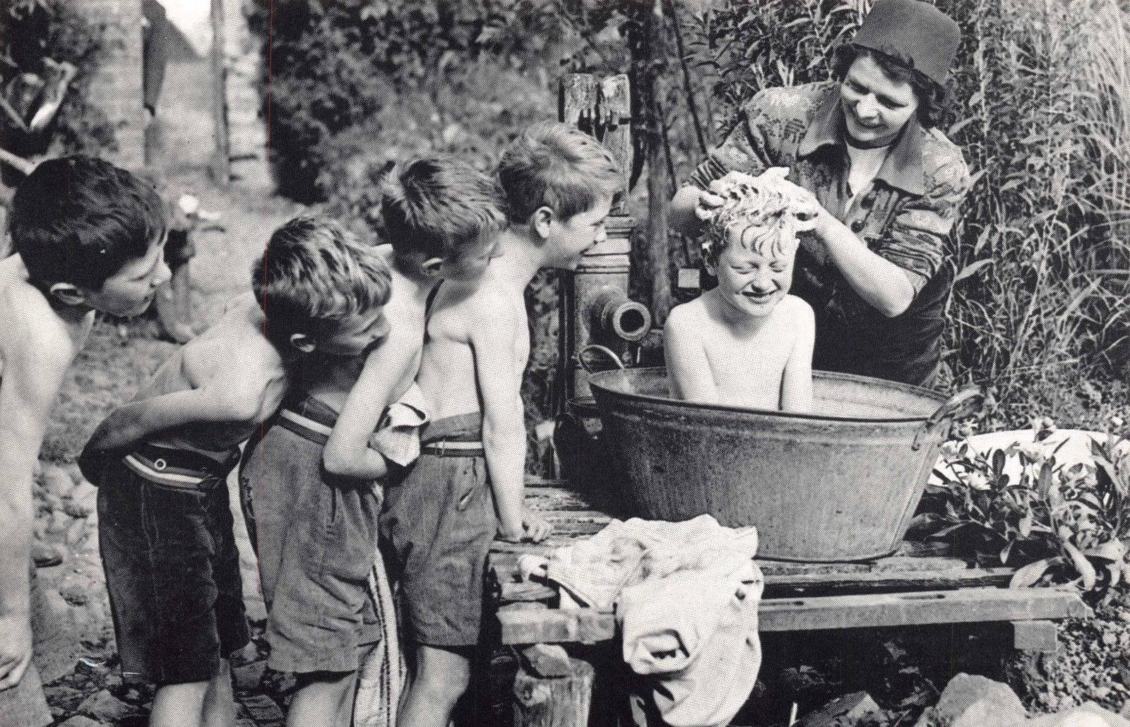 vintage-tub woman bathing children in cold water in an old vintage wash tub